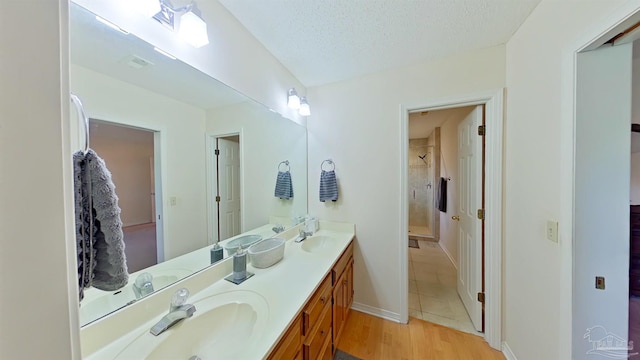 bathroom with vanity, wood-type flooring, and a textured ceiling