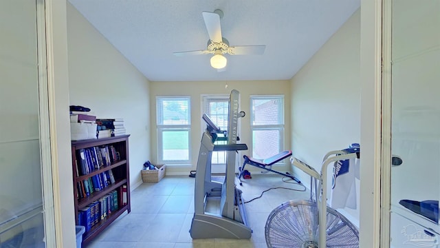 workout room with light tile patterned flooring, a textured ceiling, and ceiling fan