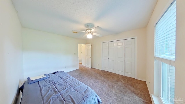 unfurnished bedroom with a textured ceiling, carpet floors, a closet, and ceiling fan