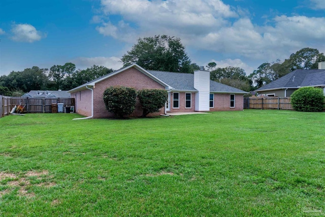 rear view of property featuring a yard