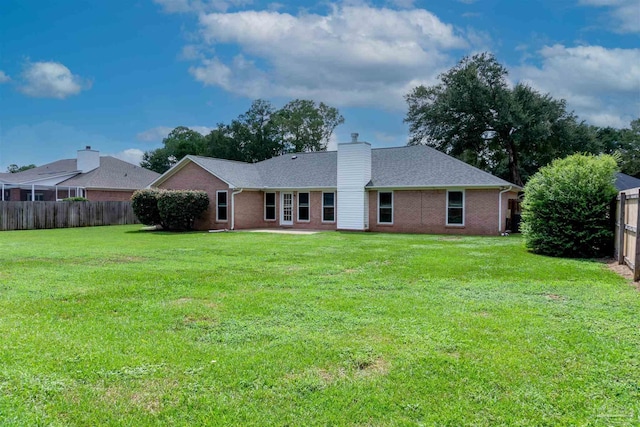 rear view of property featuring a lawn