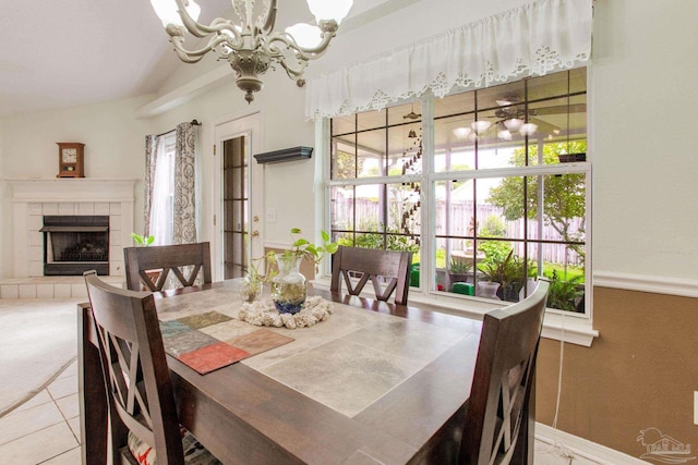 7909 Red Bean Dr, Pensacola, FL 32526 - dining room featuring a chandelier, a tiled fireplace, lofted ceiling, and tile patterned floors