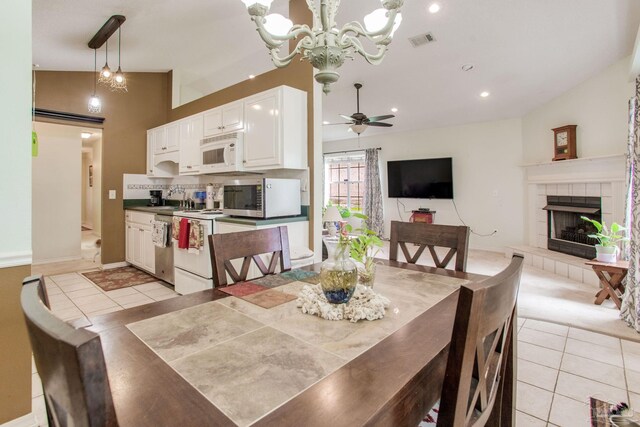7909 Red Bean Dr, Pensacola, FL 32526 - dining area with light tile patterned floors, a tile fireplace, a chandelier, recessed lighting, and vaulted ceiling