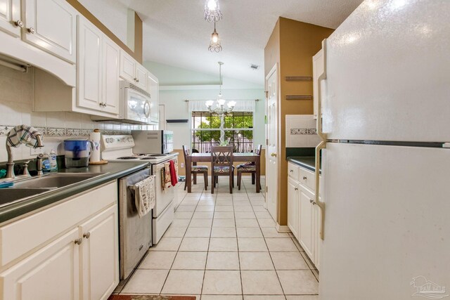 7909 Red Bean Dr, Pensacola, FL 32526 - kitchen with white appliances, vaulted ceiling, dark countertops, a chandelier, and white cabinetry