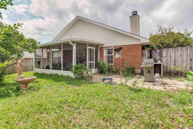 7909 Red Bean Dr, Pensacola, FL 32526 - rear view of house featuring a sunroom, brick siding, and a chimney
