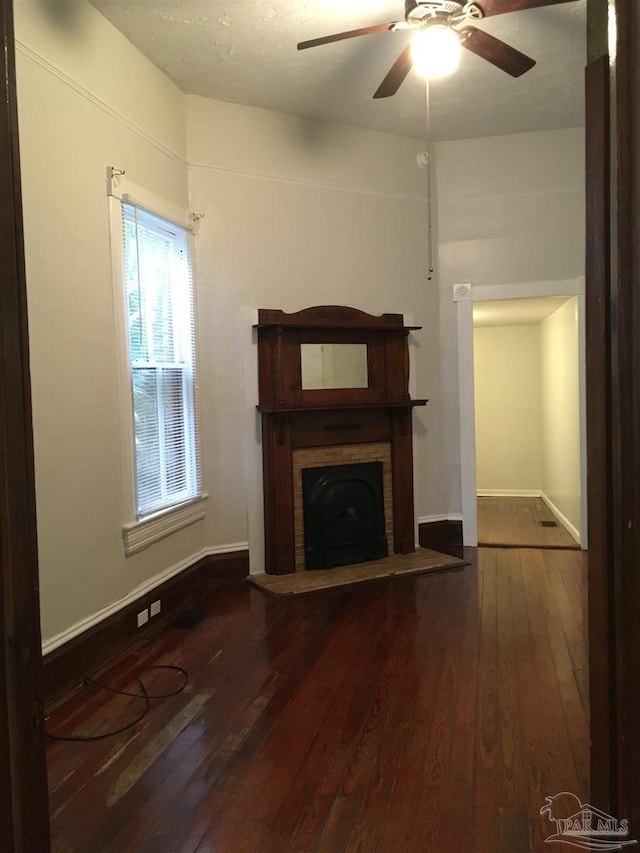 unfurnished living room featuring dark hardwood / wood-style floors and ceiling fan