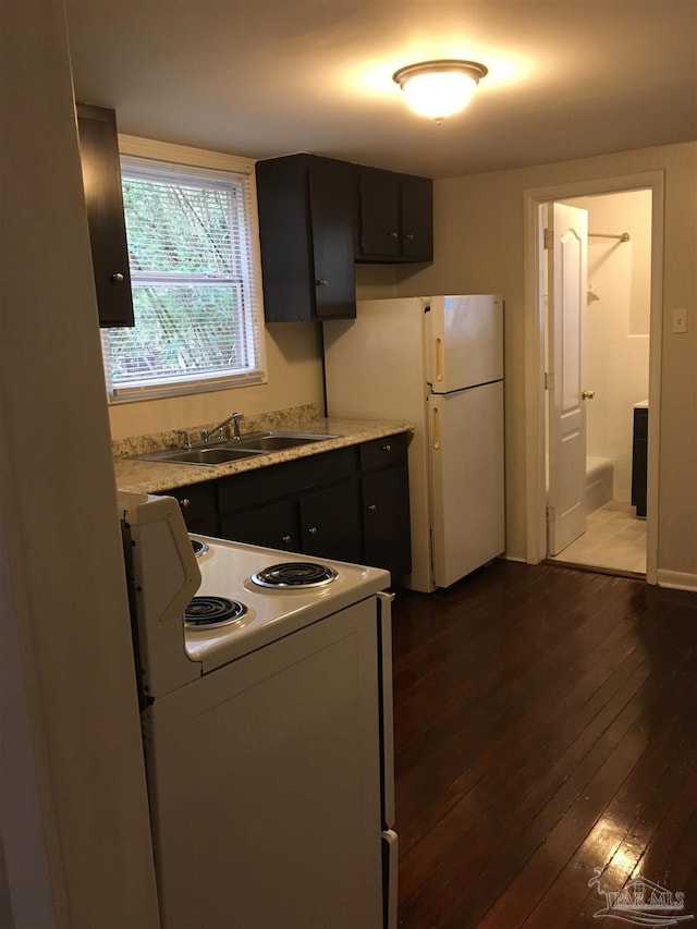 kitchen featuring sink, dark wood-type flooring, and white appliances