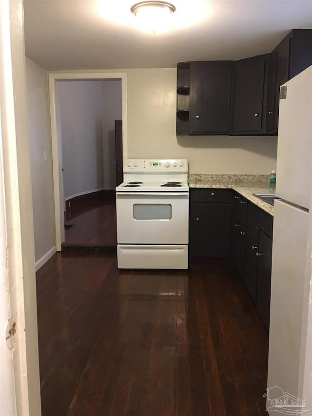 kitchen with white appliances and dark hardwood / wood-style floors