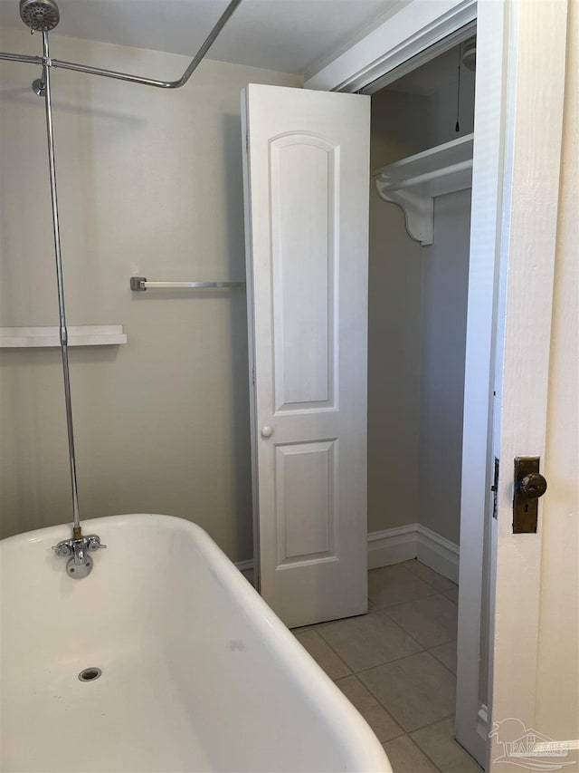 bathroom with tile patterned flooring and a bath