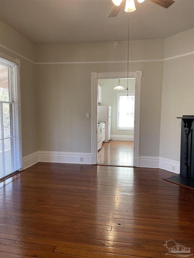 unfurnished living room with dark hardwood / wood-style floors and ceiling fan