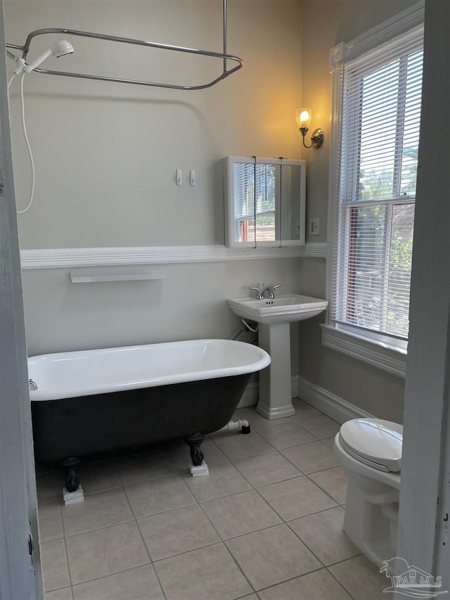 bathroom featuring tile patterned flooring, sink, a tub, and toilet