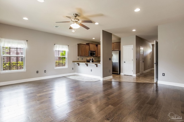 2107 Wilsons Plover Cir, Navarre, FL 32566 - unfurnished living room with ceiling fan, recessed lighting, dark wood-style floors, baseboards, and a sink