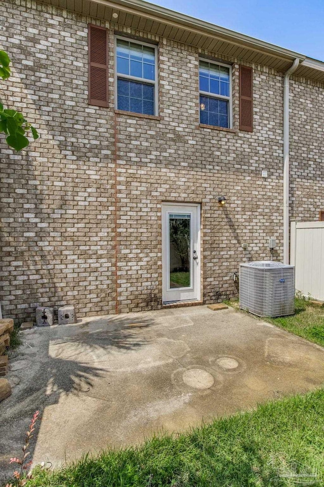 2107 Wilsons Plover Cir, Navarre, FL 32566 - rear view of house with central AC unit, a patio area, and brick siding