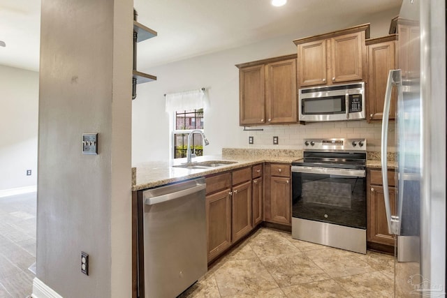 2107 Wilsons Plover Cir, Navarre, FL 32566 - kitchen featuring appliances with stainless steel finishes, a sink, backsplash, and brown cabinets