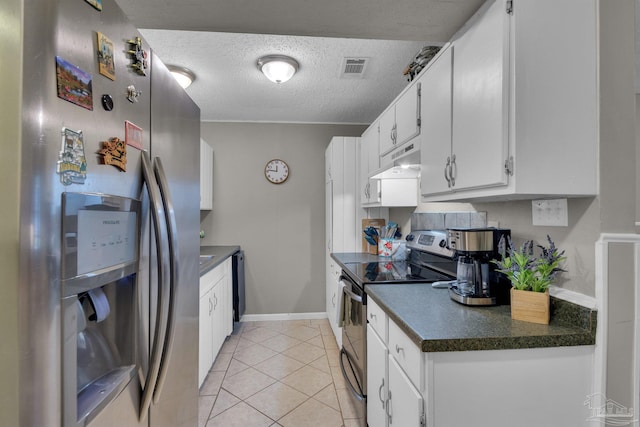 kitchen with white cabinets, light tile patterned floors, stainless steel appliances, and a textured ceiling