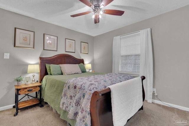 bedroom featuring a textured ceiling, ceiling fan, and light carpet