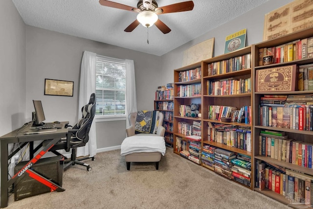 home office featuring carpet flooring, a textured ceiling, and ceiling fan