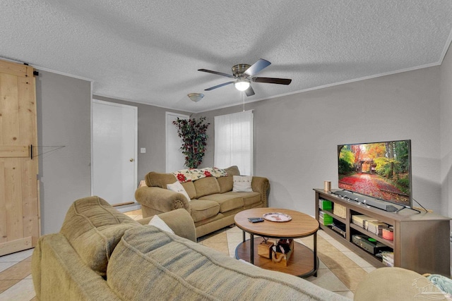 living room featuring ornamental molding, a textured ceiling, ceiling fan, light tile patterned floors, and a barn door