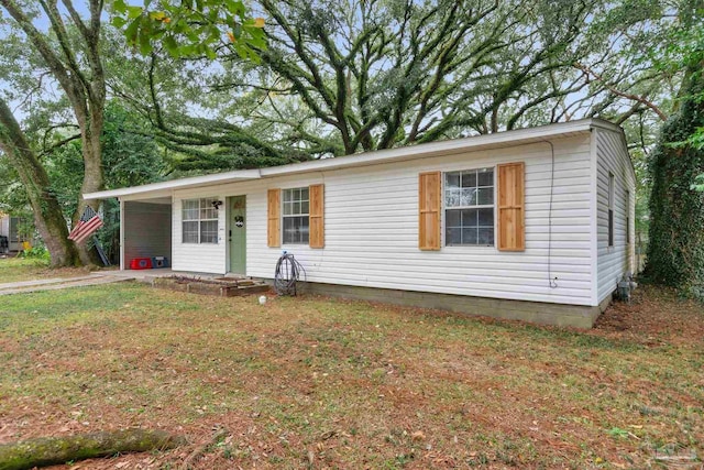 view of front of house with a carport and a front lawn