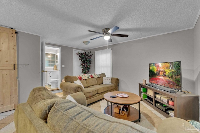 living room featuring a barn door, light tile patterned floors, a textured ceiling, and ornamental molding