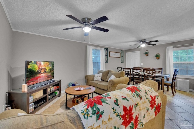 tiled living room with a textured ceiling, ceiling fan, and ornamental molding