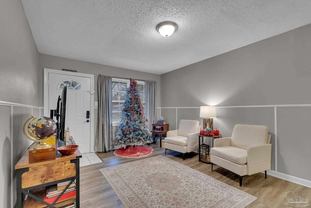 sitting room with a textured ceiling and light wood-type flooring