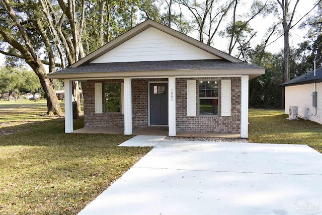 bungalow-style house featuring brick siding, covered porch, a front lawn, and roof with shingles