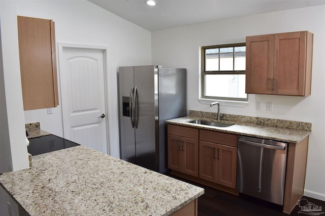 kitchen featuring recessed lighting, appliances with stainless steel finishes, light stone countertops, and a sink