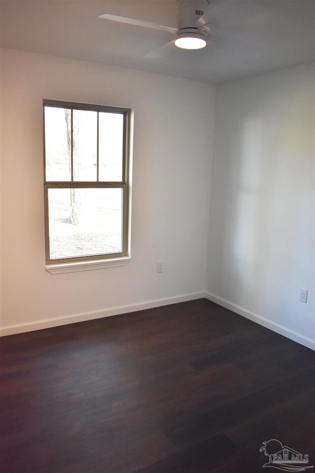 unfurnished room with ceiling fan, baseboards, and dark wood-style flooring