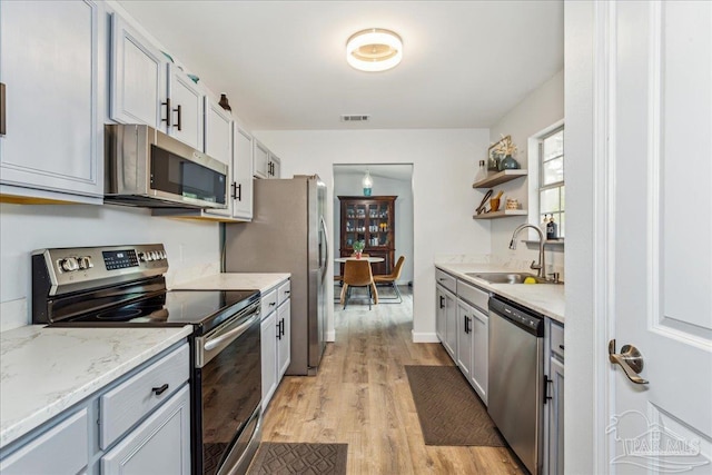 7244 Frankfort St, Navarre, FL 32566 - kitchen featuring light stone counters, sink, light hardwood / wood-style flooring, and stainless steel appliances