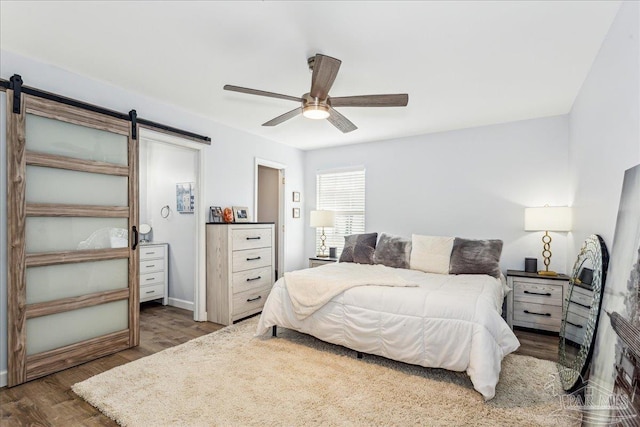 7244 Frankfort St, Navarre, FL 32566 - bedroom with ceiling fan, a barn door, and dark hardwood / wood-style flooring