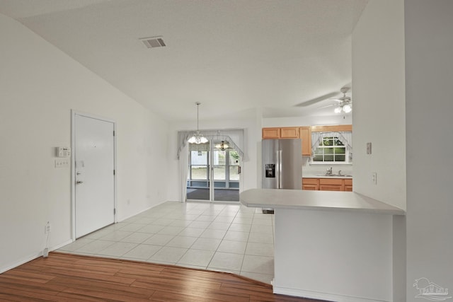 5362 Barbarosa Rd, Gulf Breeze, FL 32563 - kitchen featuring ceiling fan with notable chandelier, light wood-type flooring, stainless steel fridge with ice dispenser, light countertops, and visible vents