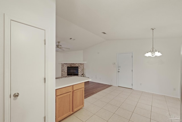 5362 Barbarosa Rd, Gulf Breeze, FL 32563 - unfurnished living room with light tile patterned flooring, visible vents, lofted ceiling, ceiling fan with notable chandelier, and a fireplace