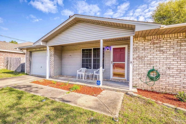 5362 Barbarosa Rd, Gulf Breeze, FL 32563 - view of front of house featuring fence, concrete driveway, an attached garage, covered porch, and brick siding