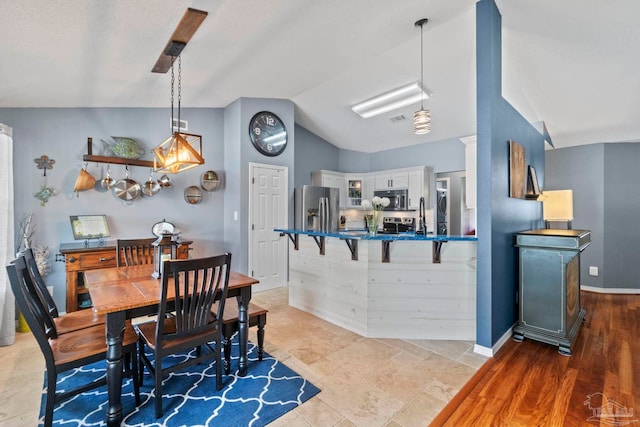 dining area with visible vents, baseboards, and lofted ceiling