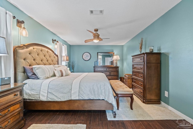 bedroom with a ceiling fan, baseboards, visible vents, and wood finished floors