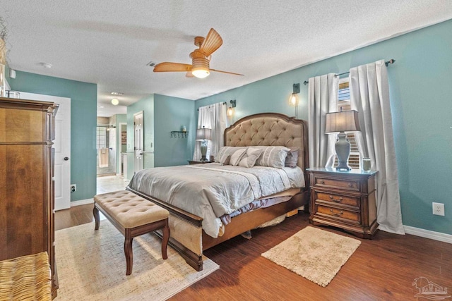 bedroom featuring baseboards, a textured ceiling, and wood finished floors