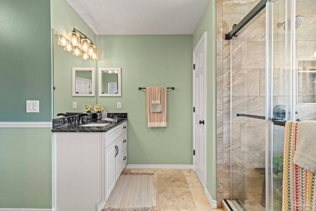 bathroom with vanity, baseboards, and a stall shower