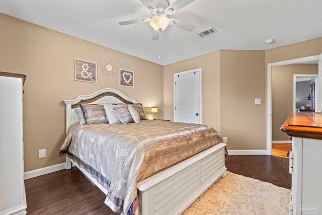 bedroom with visible vents, a ceiling fan, baseboards, and wood finished floors