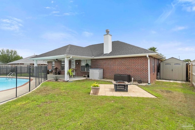 rear view of house featuring a storage shed, a patio area, brick siding, fence, and an outdoor fire pit