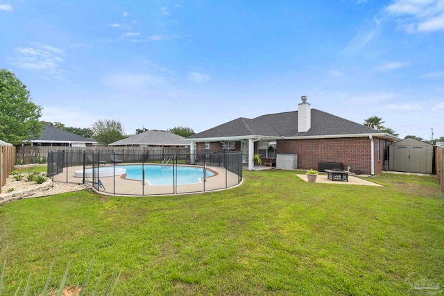 view of swimming pool featuring a fenced backyard, a fire pit, a patio area, and a storage shed