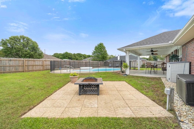 view of yard with ceiling fan, a fenced in pool, a fenced backyard, a patio, and a fire pit