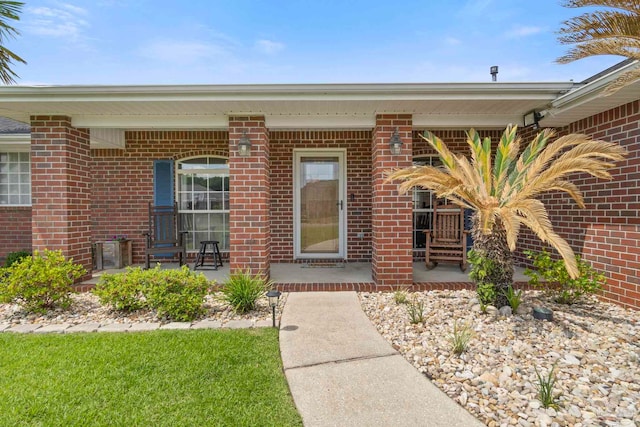 entrance to property featuring brick siding