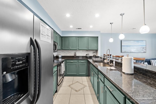 kitchen featuring appliances with stainless steel finishes, visible vents, a sink, and green cabinets