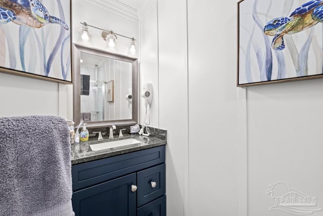 bathroom featuring walk in shower, crown molding, and vanity