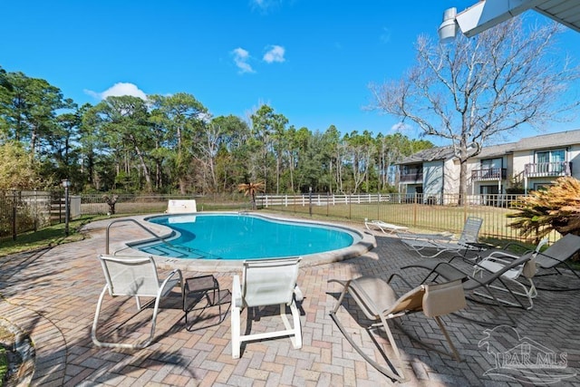 community pool with fence and a patio