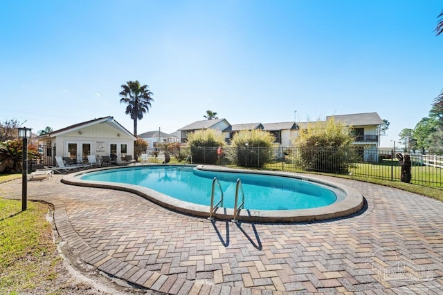 pool featuring french doors, fence, and a patio