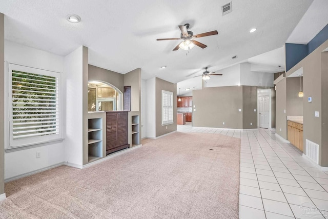 unfurnished living room featuring a textured ceiling, light colored carpet, and ceiling fan