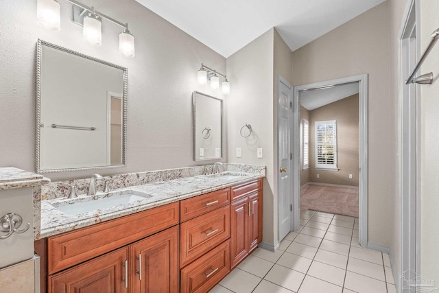 bathroom featuring tile patterned flooring, vanity, and lofted ceiling