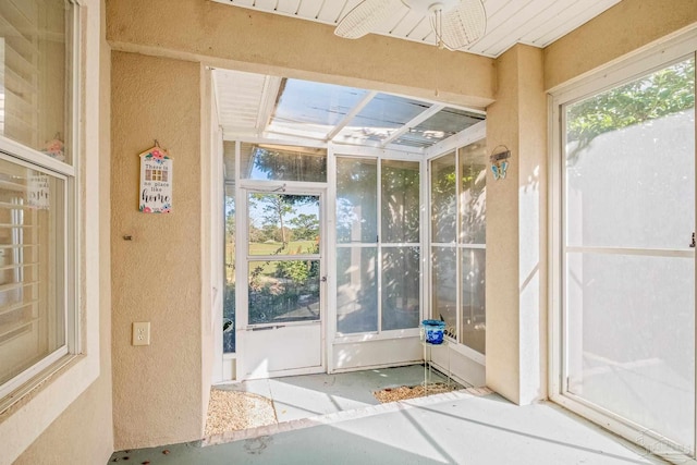 unfurnished sunroom with ceiling fan